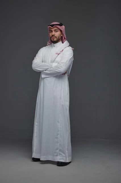Saudi Man in Traditional Thobe Standing on Grey Background