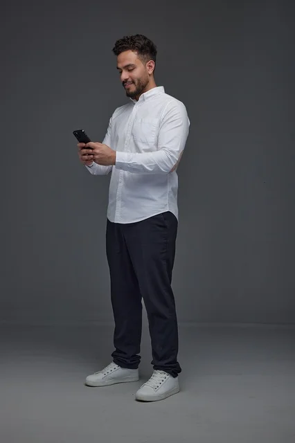 Saudi Man Using Smartphone on Grey Background