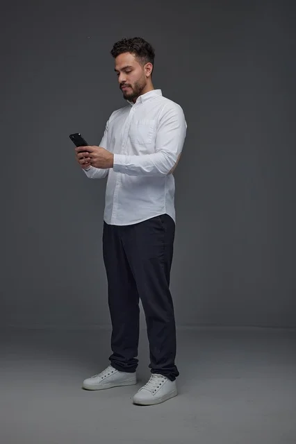 Saudi Man Using Smartphone on Grey Studio Background