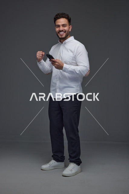رجل سعودي يستخدم الهاتف الذكي مع إيماءة النجاح