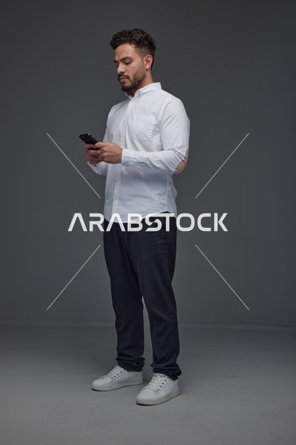 رجل سعودي يستخدم الهاتف الذكي في الاستوديو