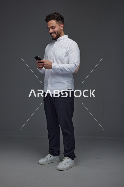 رجل سعودي يستخدم الهاتف الذكي في استوديو تصوير