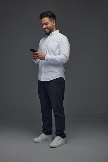 Saudi Man Using Smartphone on Gray Studio Background