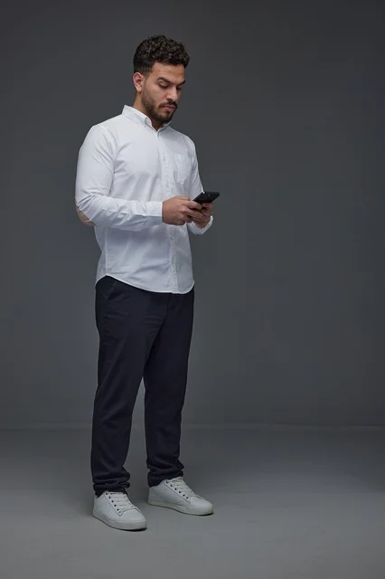 Saudi Man Using Smartphone on Gray Studio Background