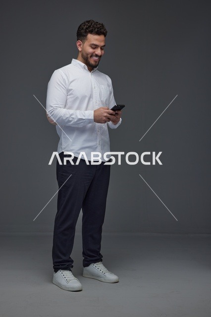 رجل سعودي يستخدم الهاتف الذكي في الاستوديو