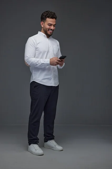 Saudi Man Using Smartphone on Gray Studio Background