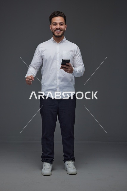 رجل عربي يستخدم الهاتف الذكي في استوديو