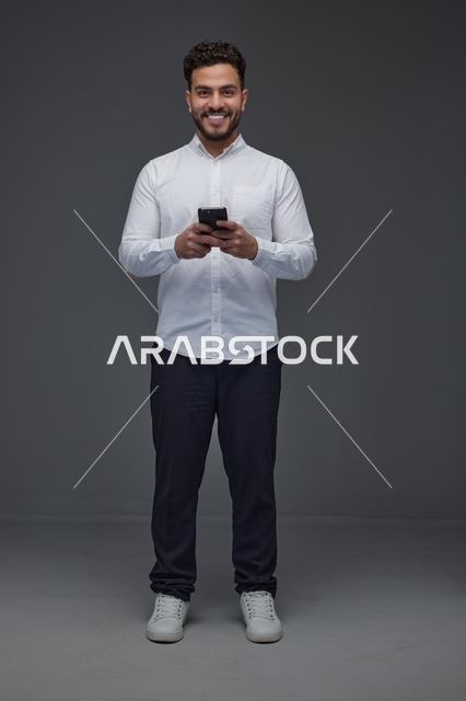 رجل سعودي يستخدم الهاتف الذكي في الاستوديو
