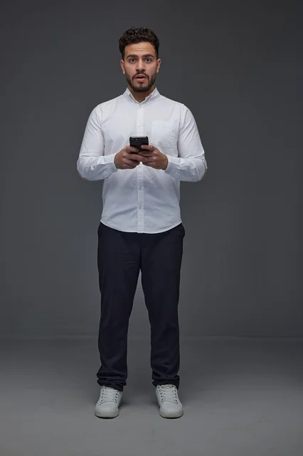 Saudi Man Using Smartphone with Surprised Expression