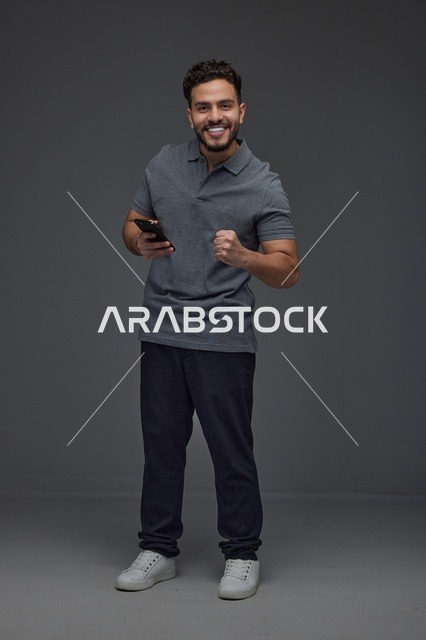 رجل سعودي يستخدم الهاتف الذكي بتعبيرات النجاح