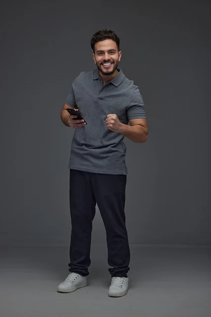 Saudi Man Using Smartphone with Success Gesture