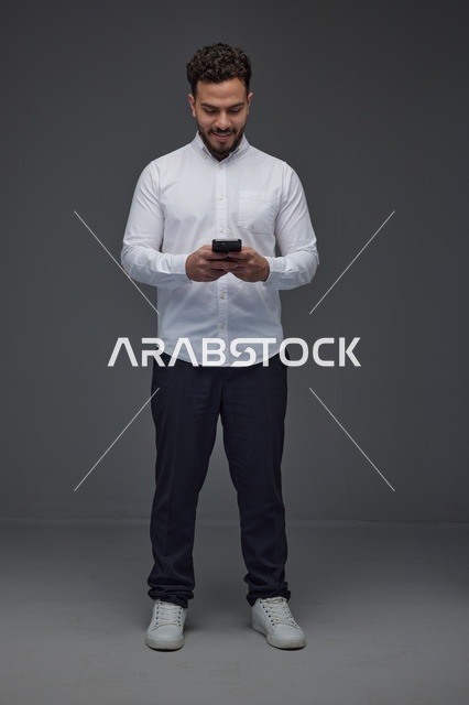 رجل سعودي يستخدم الهاتف الذكي في الاستوديو