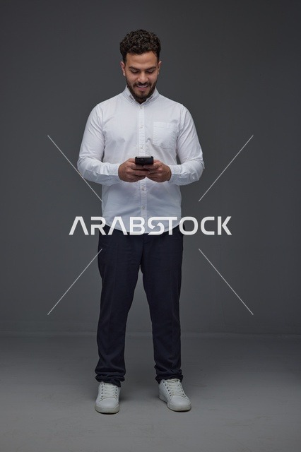 Saudi Man Using Smartphone in Studio White Shirt Shot