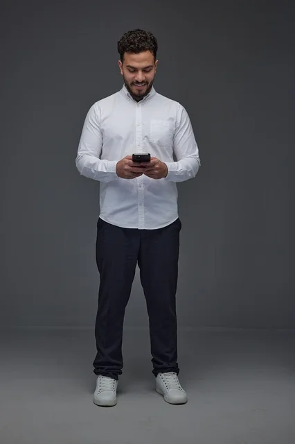 Saudi Man Using Smartphone in Studio White Shirt Shot