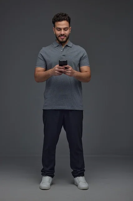 Saudi Man Using Smartphone on Grey Background