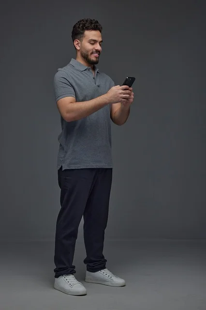 Saudi Man Using Smartphone in Grey Studio Background