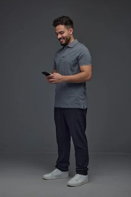Saudi Man Using Smartphone on Grey Background