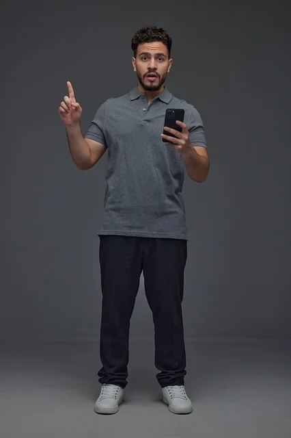 Saudi Man Holding Smartphone Pointing Upwards