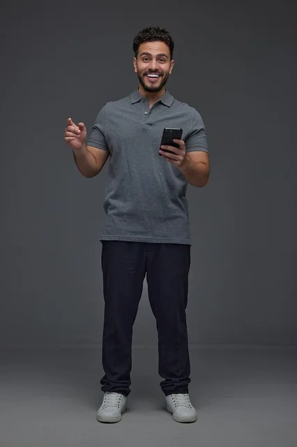 Smiling Saudi Man Holding Smartphone on Grey Background