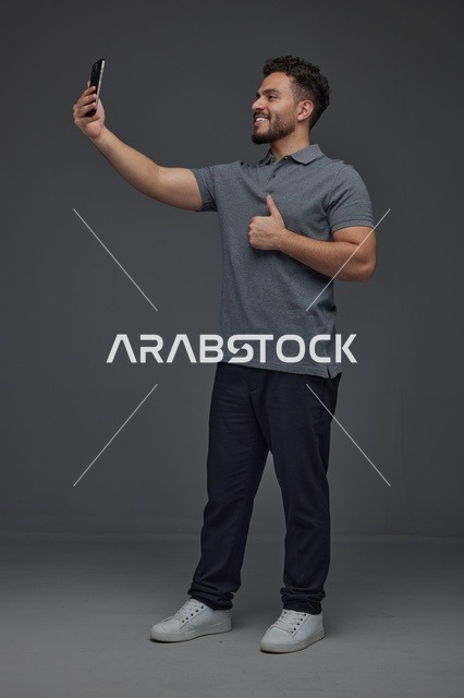 رجل سعودي يلتقط سيلفي مع علامة الإعجاب في الاستوديو