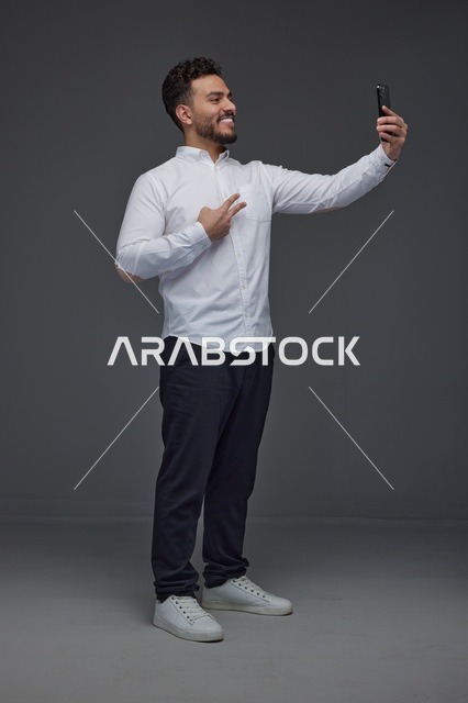 رجل سعودي يلتقط صورة سيلفي بعلامة النصر