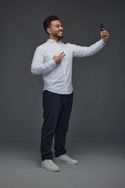 Saudi Man Taking Smartphone Selfie with Victory Sign