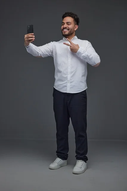 Saudi Man Taking Selfie with Smartphone in Studio Portrait