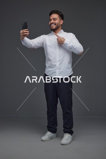 رجل سعودي يلتقط سيلفي بالهاتف الذكي في الاستوديو