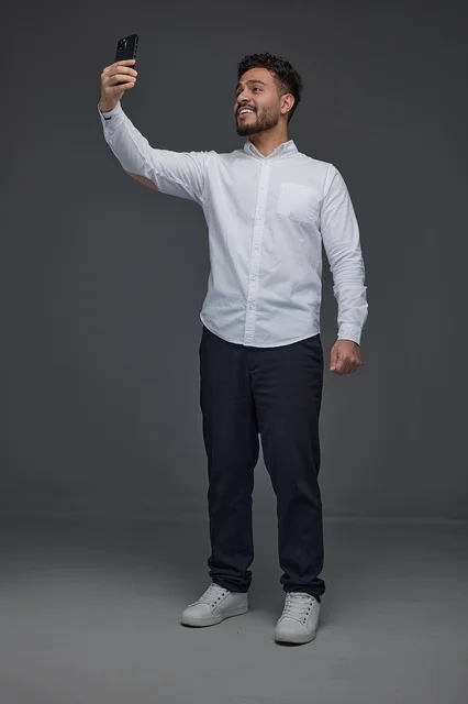 Saudi Man Taking Selfie with Smartphone in Studio Portrait