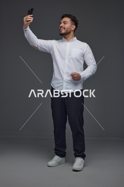 رجل سعودي يلتقط صورة سيلفي بالهاتف الذكي
