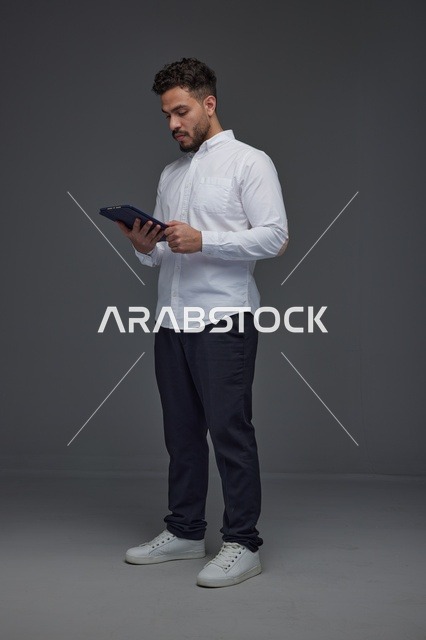 رجل سعودي يستخدم جهازاً لوحياً في الاستوديو