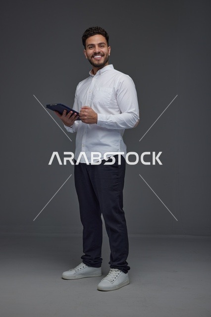 Man Holding Digital Tablet on Grey Studio Background