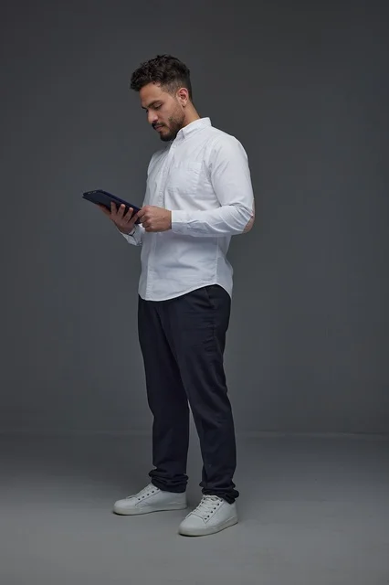 Saudi Man Using Tablet on Grey Studio Background
