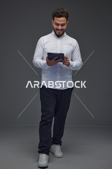 Saudi Man Using Tablet in Grey Studio