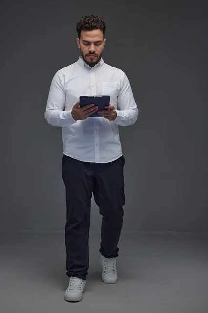 Saudi Man Using Digital Tablet in Studio Grey Background