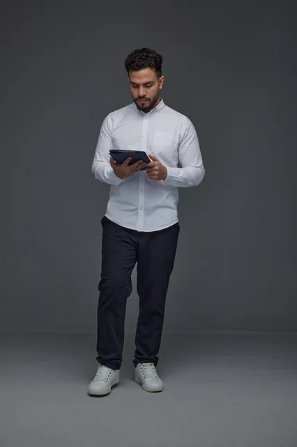 Saudi Man Using Digital Tablet in Grey Studio Background
