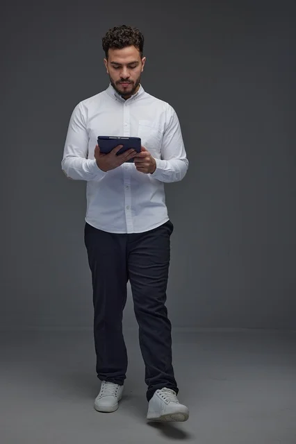 Saudi Man Using Digital Tablet on Grey Background
