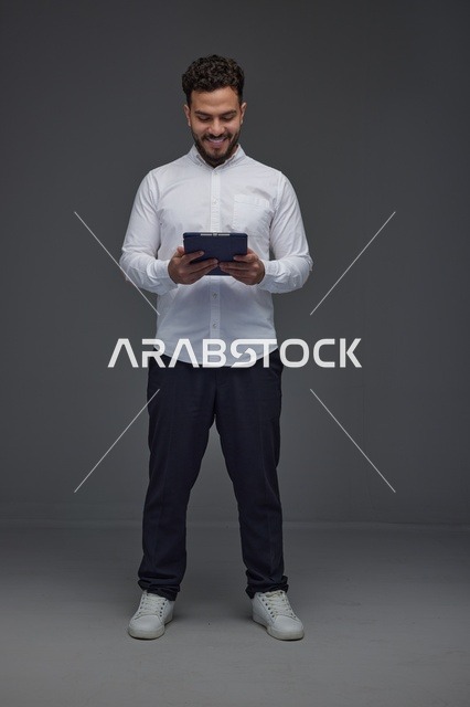 رجل سعودي يستخدم جهاز لوحي في الاستوديو
