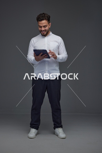 رجل سعودي يستخدم جهاز لوحي في الاستوديو