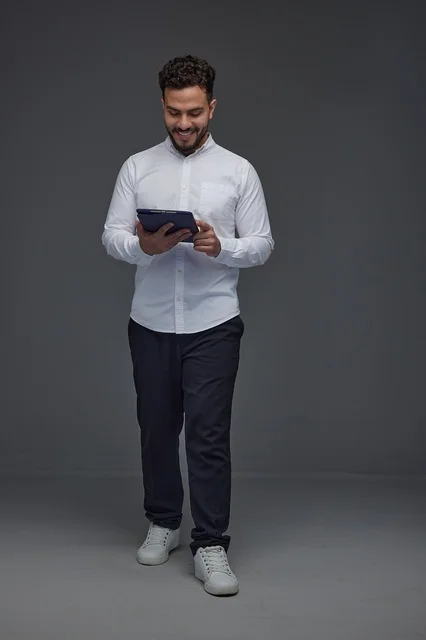 Saudi Man Using Digital Tablet on Grey Studio Background