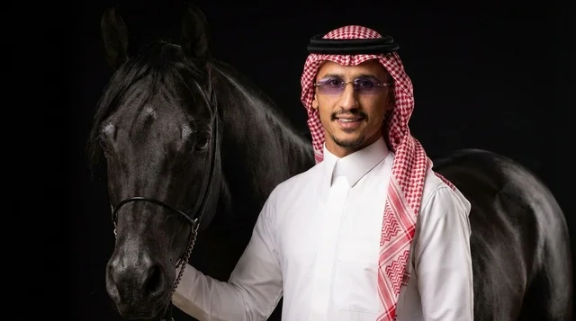 رجل سعودي مع خيل عربي أصيل بالزي التقليدي الرسمي