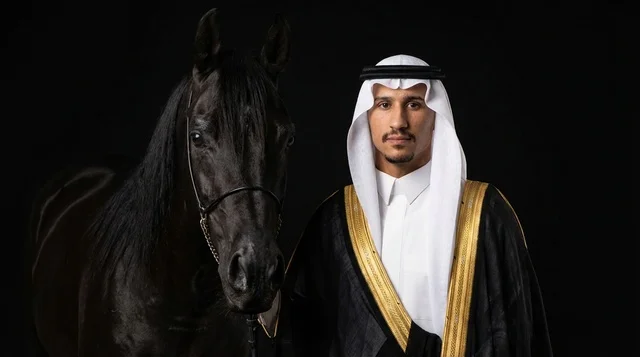 رجل سعودي بالزي الرسمي مع خيل عربي أسود في استوديو