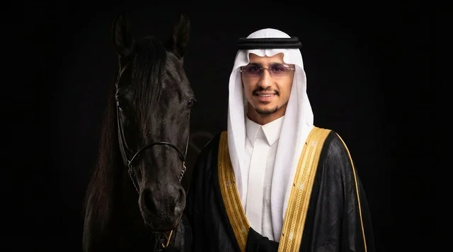 رجل سعودي بالبشت الرسمي مع خيل عربي أصود
