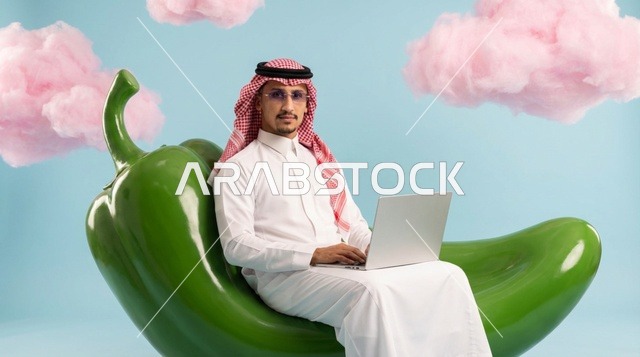 رجل سعودي يستخدم الكمبيوتر المحمول فوق فلفل أخضر