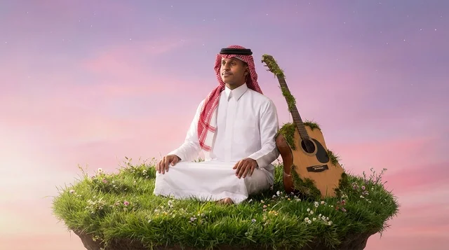 رجل سعودي يتأمل على جزيرة طائرة مع جيتار