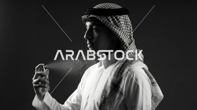 شاب سعودي يرش العطر بورتريه أبيض وأسود بالاستوديو