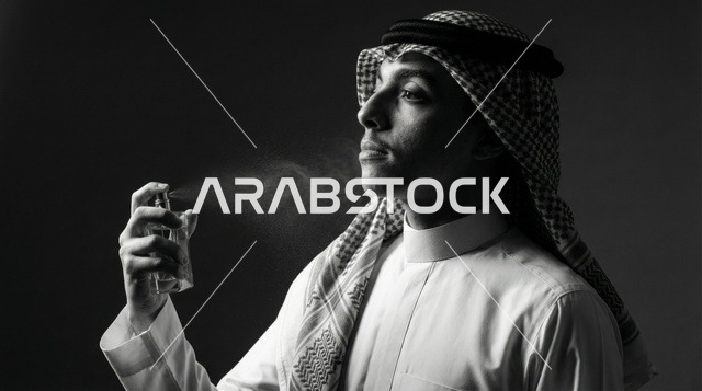 رجل عربي يرتدي الثوب التقليدي يرش العطر بورتريه