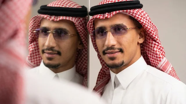 Saudi Man in Traditional Attire Looking in Mirror