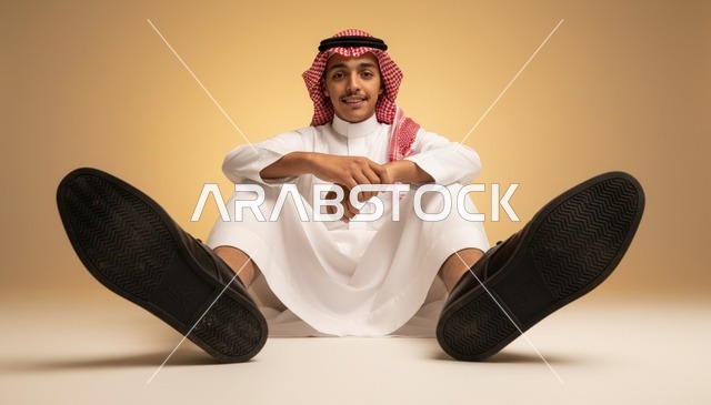 شاب سعودي بالثوب التقليدي يجلس في استوديو