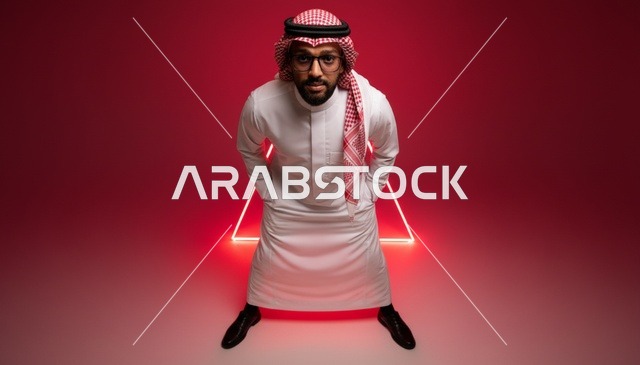 رجل سعودي بالثوب مع خلفية نيون حمراء في استوديو